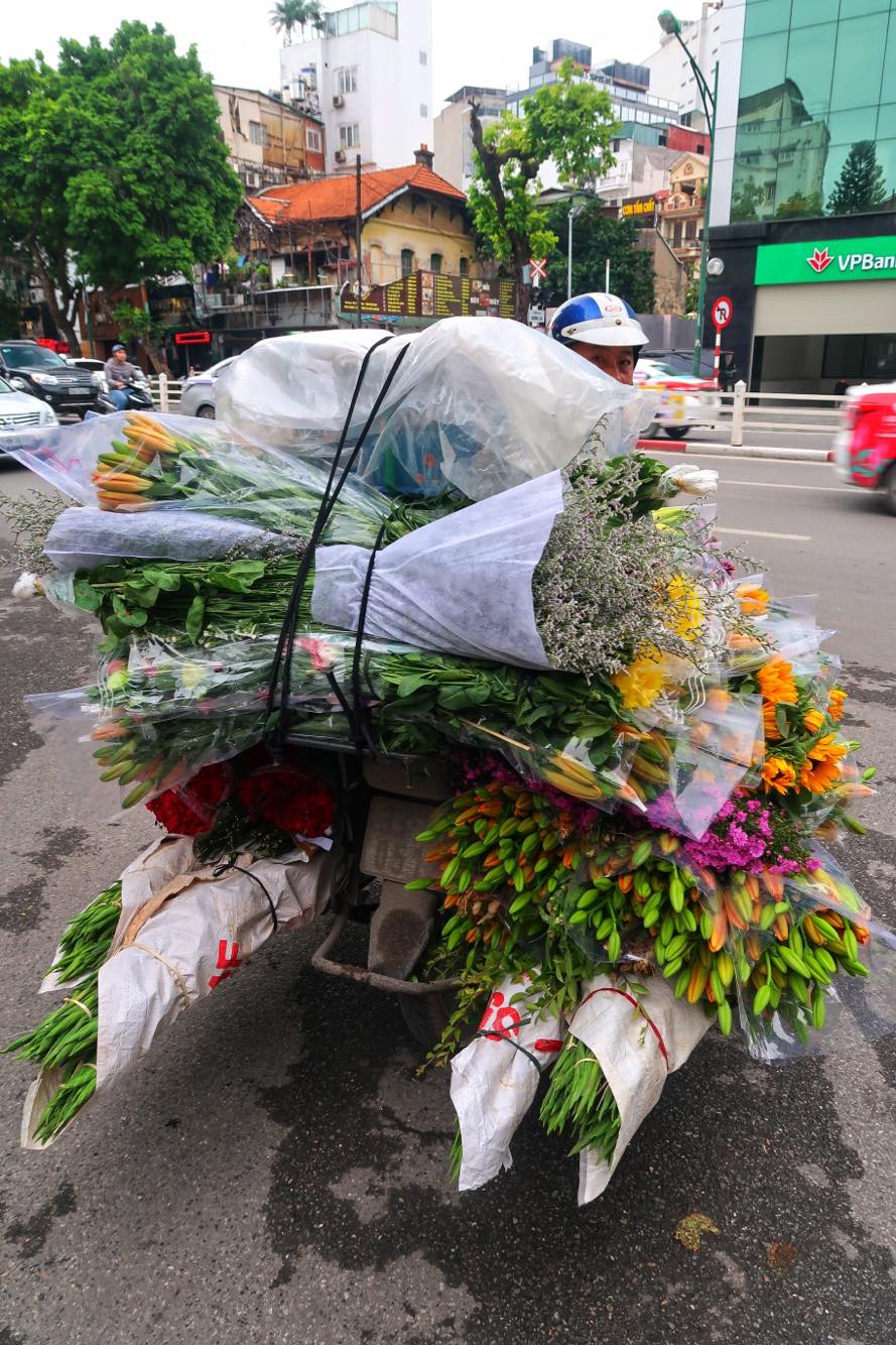 En scooter helt fyldt op med blomster i Hanoi